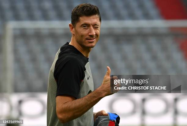 Barcelona's Polish forward Robert Lewandowski gives a thumbs up as he arrives for a training session in Munich, southern Germany on September 12 on...