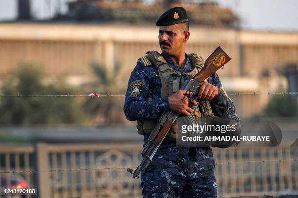 Policeman stands guard as Shiite Muslim pilgrims march from Iraq's capital Baghdad on their way to the holy city of Karbala, ahead of the Arbaeen...