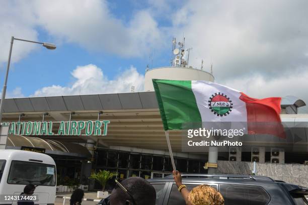 Female demonstrator waves a Nigerian Labour Congress flag at the Nnamdi Azikiwe International Airport in Abuja, during the Federal Airport Authority...
