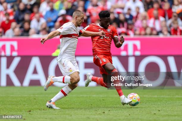Waldemar Anton of VfB Stuttgart and Alphonso Davies of Bayern Muenchen battle for the ball during the Bundesliga match between FC Bayern München and...