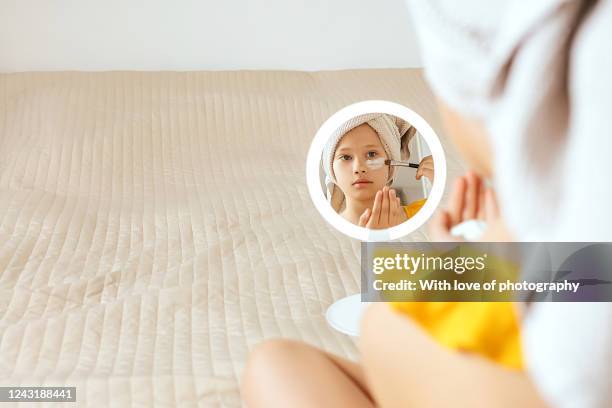 8 year old little girl doing beauty spa face mask at home due to coronavirus - une seule petite fille photos et images de collection