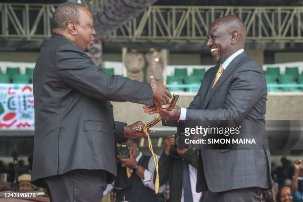 Former Kenyan president Uhuru Kenyatta shakes hands with incoming President William Ruto at the Moi International Sports Center Kasarani in Nairobi,...