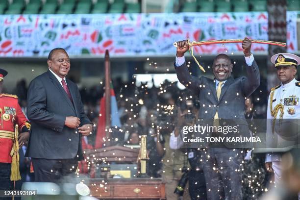 Outgoing Kenya President Uhuru Kenyatta looks on as President William Ruto lifts a sword at the Moi International Sports Center Kasarani in Nairobi,...