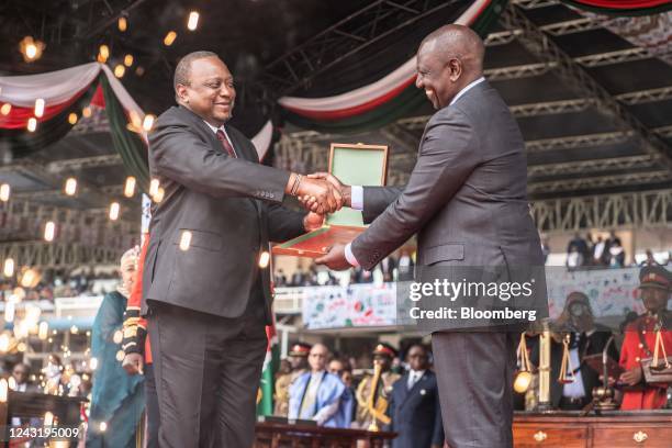 William Ruto, newly-elected president of Kenya, right, receives an instrument of power Uhuru Kenyatta, Kenya's former president, during his...