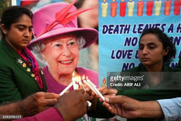 Christians light candles to pay tribute to late Queen Elizabeth II, in Lahore on September 13, 2022. - Queen Elizabeth II, the longest-serving...