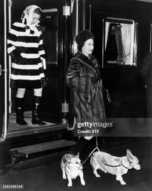 Queen Elizabeth II, followed by her daughter Princess Anne, gets off the train with her dogs, in October 1969.