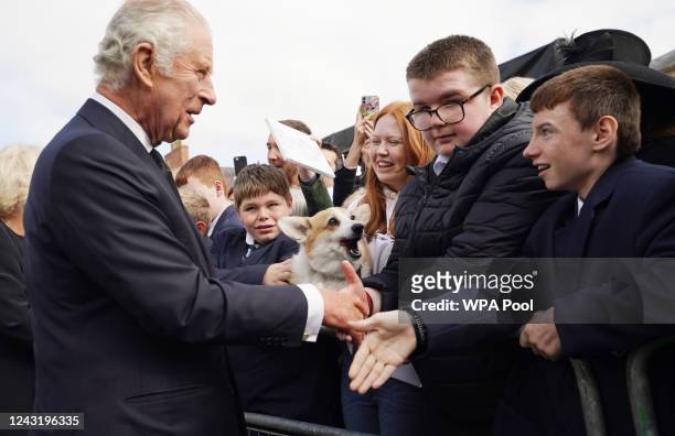 Crowds cheer including a woman with a Corgi dog as King Charles III and Camilla, Queen Consort arrive for a visit to Hillsborough Castle on September...