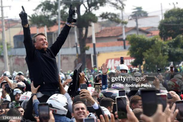 President of Brazil and presidential candidate Jair Bolsonaro reacts with supporters during in a motorcade rally as part of a re-election campaign in...