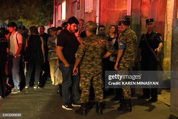 Relatives of servicemen, who were wounded in night border clashes between Armenia and Azerbaijan, gather outside a military hospital in Yerevan on...