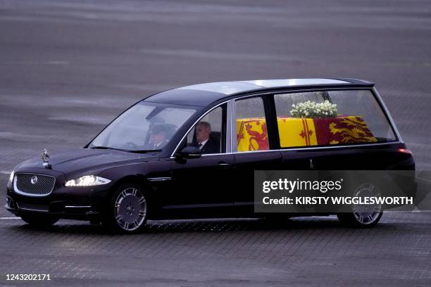 The coffin of Queen Elizabeth II is taken away in the Royal Hearse from the Royal Air Force Northolt airbase on September 13 to travel to Buckingham...