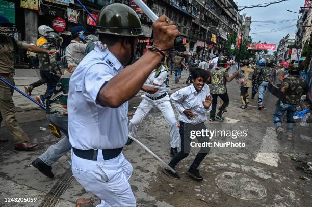 Policemen wield their batons against a supporter of India's ruling Bharatiya Janata Party during a demonstration in Kolkata on September 13 to...