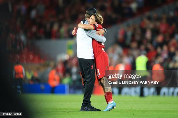 Liverpool's German manager Jurgen Klopp hugs Liverpool's Greek defender Kostas Tsimikas at the end of the UEFA Champions League group A football...
