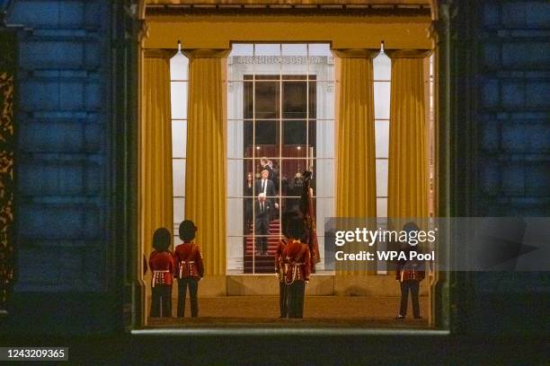 King Charles III, Prince Harry, Duke of Sussex, and Meghan, Duchess of Sussex wait for the the Royal Hearse carrying the coffin of Queen Elizabeth II...