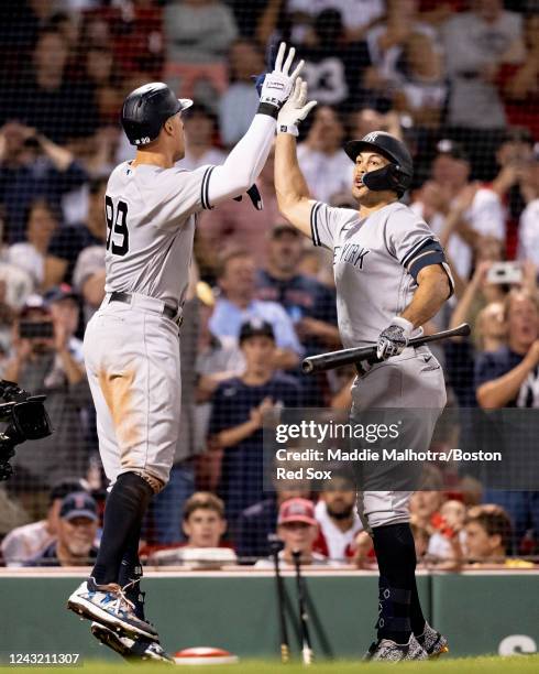 Aaron Judge of the New York Yankees reacts with teammate Giancarlo Stanton after hitting a home run during the sixth inning of a game against the...