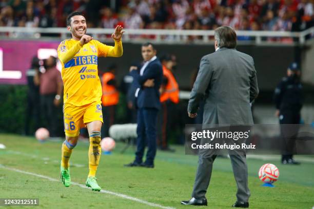 Juan Vigon of Tigres celebrates with Miguel Herrera, coach of Tigres, after scoring his team's first goal during the 9th round match between Chivas...