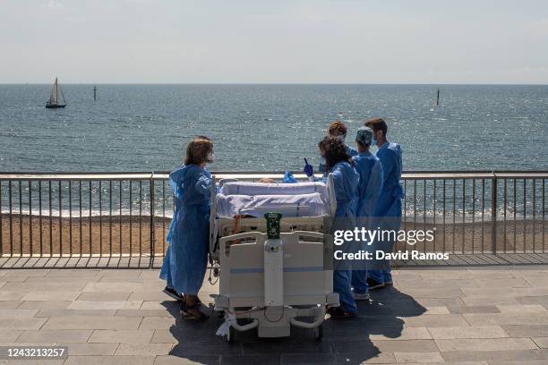 Hospital patient Isidre Correa is taken to the seaside by intensive health care staff outside the Hospital del Mar on June 03, 2020 in Barcelona,...