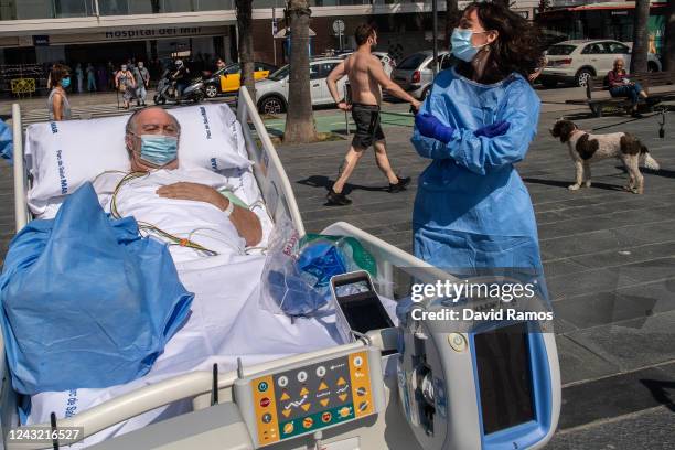 Hospital patient Isidre Correa is taken to the seaside by intensive health care staff outside the Hospital del Mar on June 03, 2020 in Barcelona,...