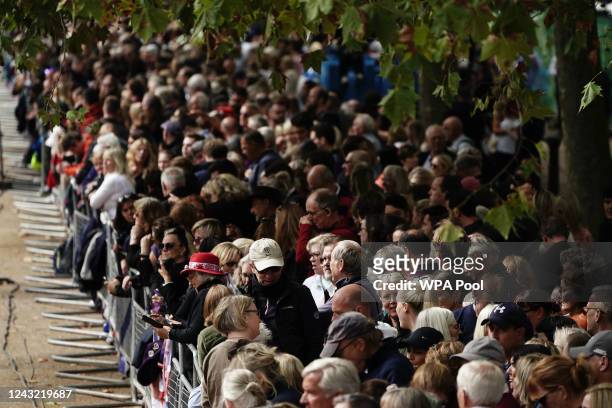Crowds gather along the Mall ahead of the coffin of late Queen Elizabeth II departing in procession to Westminster Hall on September 14, 2022 in...