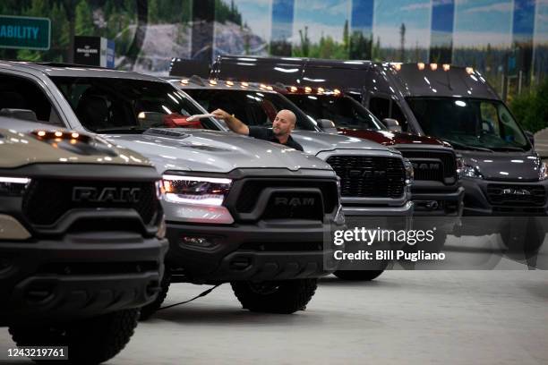 Worker cleans a RAM truck at the 2022 North American International Auto Show on September 14, 2022 in Detroit, Michigan.The NAIAS opens to the public...