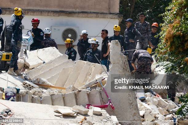 Jordanian rescue teams search for 10 people still missing under the rubble of a collapsed four-storey building in the capital Amman on September 14 a...