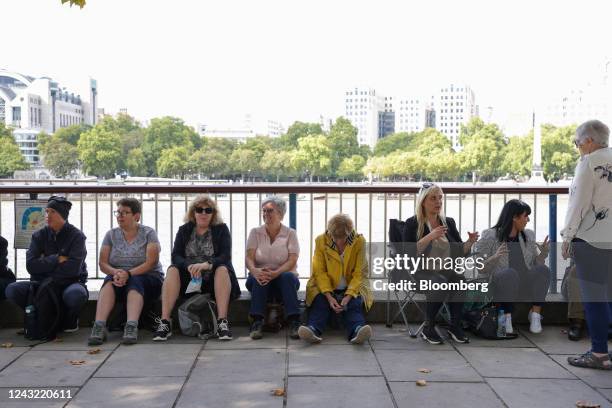 Members of public sit in the queue at South Bank, to see Queen Elizabeth II's coffin lying in state at Westminster Hall, in London, UK, on Wednesday,...