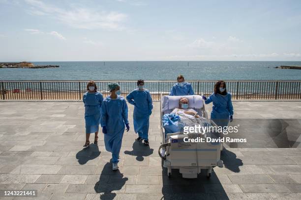 Hospital patient Isidre Correa is taken to the seaside by intensive health care staff outside the Hospital del Mar on June 03, 2020 in Barcelona,...