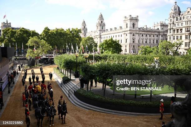 The coffin of Queen Elizabeth II, adorned with a Royal Standard and the Imperial State Crown, pulled by a Gun Carriage of The King's Troop Royal...