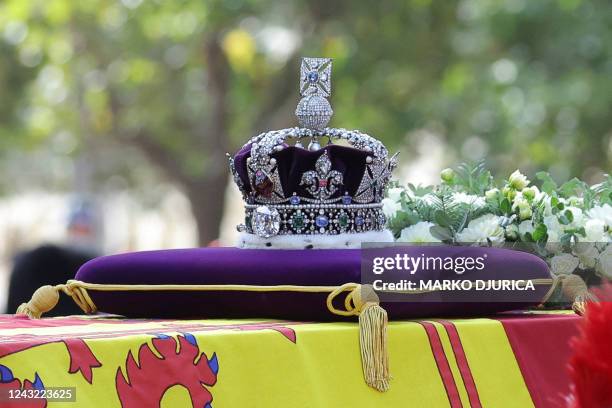 The coffin of Queen Elizabeth II, adorned with a Royal Standard and the Imperial State Crown and pulled by a Gun Carriage of The King's Troop Royal...