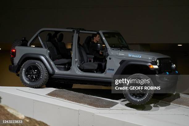 The Jeep Wrangler 4xe Willys drives over an obstacle during the Jeep Press conference at the 2022 North American International Auto Show in Detroit,...