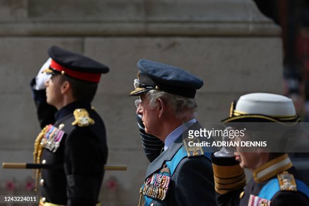 Britain's King Charles III and Britain's Princess Anne, Princess Royal salute as they pass the Cenotpah war memorial as they walk behind the coffin...