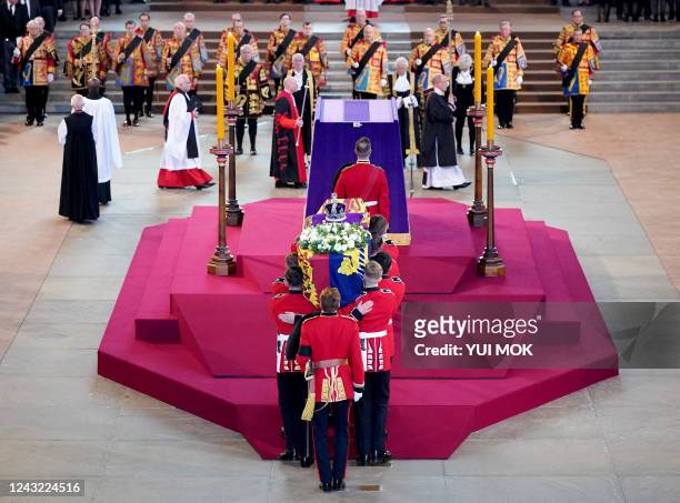 Pallbearers from The Queen's Company, 1st Battalion Grenadier Guards places the coffin of Britain's Queen Elizabeth II on a Catafalque inside...