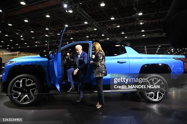 President Joe Biden, with General Motors CEO Mary Barra, looks at a Chevrolet Silverado EV as he tours the 2022 North American International Auto...