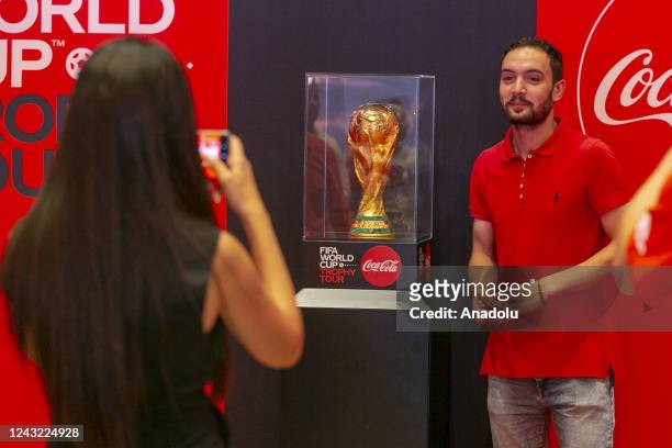 Tunisian man poses for photo with FIFA World Cup Trophy in Tunusia's capital Tunis as part of "FIFA World Cup Trophy Tour" on September 14, 2022.