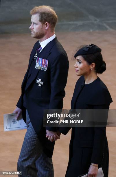 Britain's Prince Harry, Duke of Sussex and Meghan, Duchess of Sussex leave after a service for the reception of Queen Elizabeth II's coffin at...