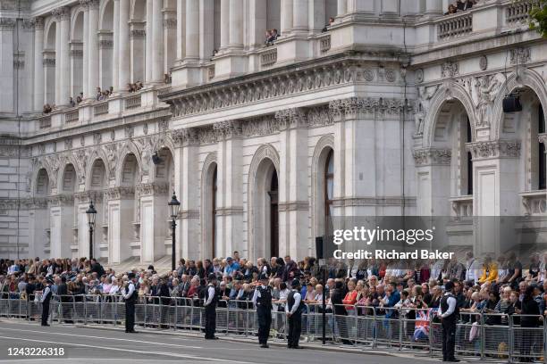 Following the death, at the age of 96, of Queen Elizabeth II in Scotland, government workers watch the crowds and police officers below from their...