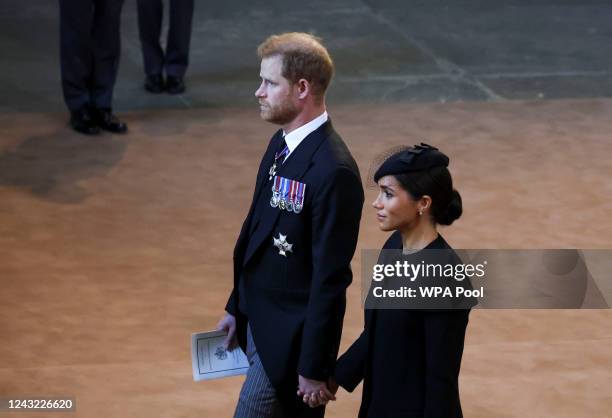 Prince Harry and Meghan, Duchess of Sussex walk as procession with the coffin of Britain's Queen Elizabeth arrives at Westminster Hall from...