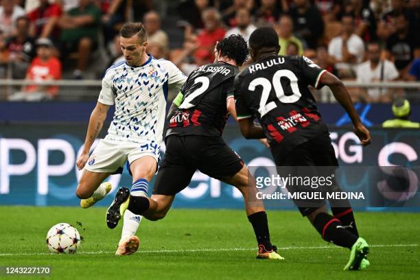 Dinamo Zagreb's Croatian forward Mislav Orsic fights for the ball with AC Milan's Italian defender Davide Calabria and AC Milan's French defender...