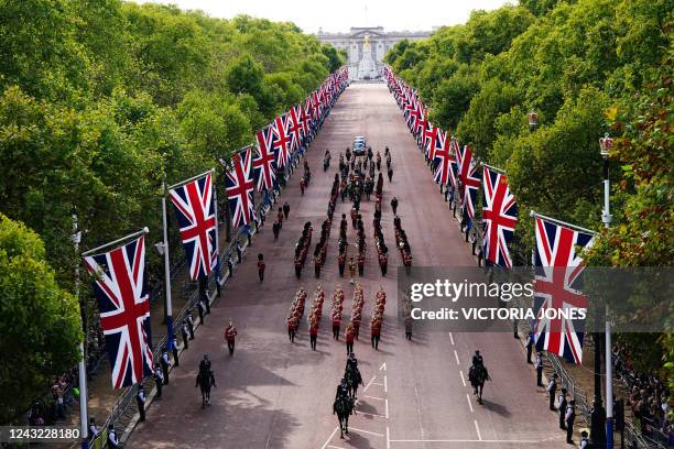 General view of the coffin of Queen Elizabeth II, adorned with a Royal Standard and the Imperial State Crown and pulled by a Gun Carriage of The...