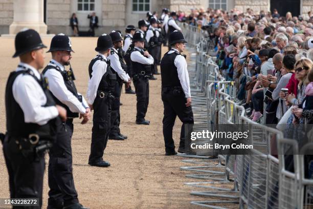 Police officer talks to members of the public on Horse Guards parade ahead of the ceremonial procession of the gun carriage carrying Queen Elizabeth...