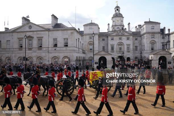 The coffin of Queen Elizabeth II, adorned with a Royal Standard and the Imperial State Crown and pulled by a Gun Carriage of The King's Troop Royal...