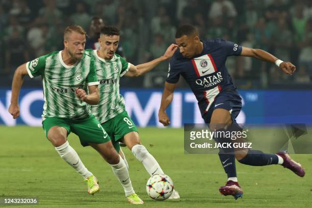 Maccabi Haifa's Swedish defender Daniel Sundgren and Maccabi Haifa's Israeli midfielder Dolev Haziza attempt to block Paris Saint-Germain's French...
