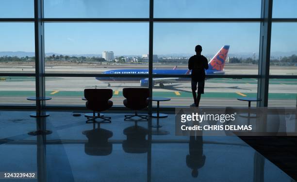 Person watches planes take off from the Tom Bradley International terminal at Los Angeles International Airport in Los Angeles, California, on August...