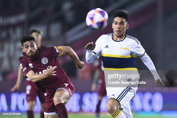 Guillermo Fernandez of Boca Juniors runs after the ball against Lautaro Acosta during a match between Lanus and Boca Juniors as part of Liga...