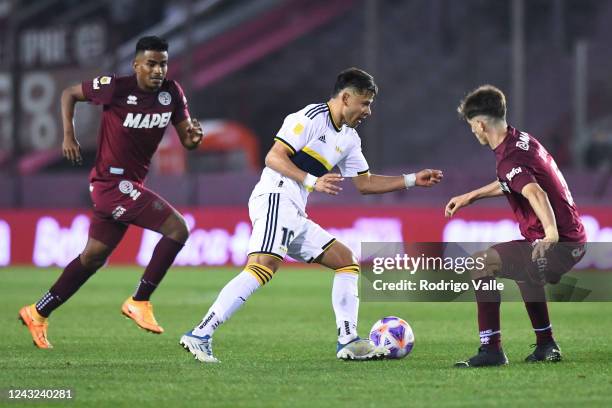 Oscar Romero of Boca Juniors drives the ball against Raul Loaiza and Tomas Belmonte of Lanus during a match between Lanus and Boca Juniors as part of...
