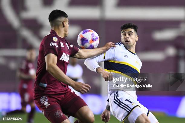 Martin Payero of Boca Juniors fights for the ball with Matias Perez of Lanus during a match between Lanus and Boca Juniors as part of Liga...