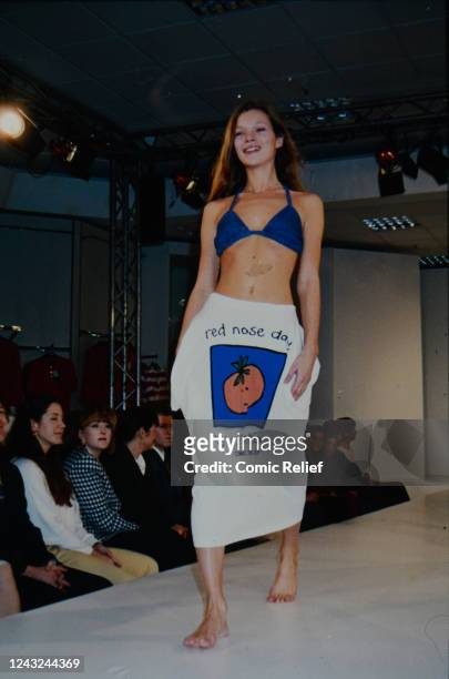 Kate Moss modelling the T-shirt of Red Nose Day 1993 from a photoshoot for the Clothes Show at C&A in Marble Arch, 1993 in England.