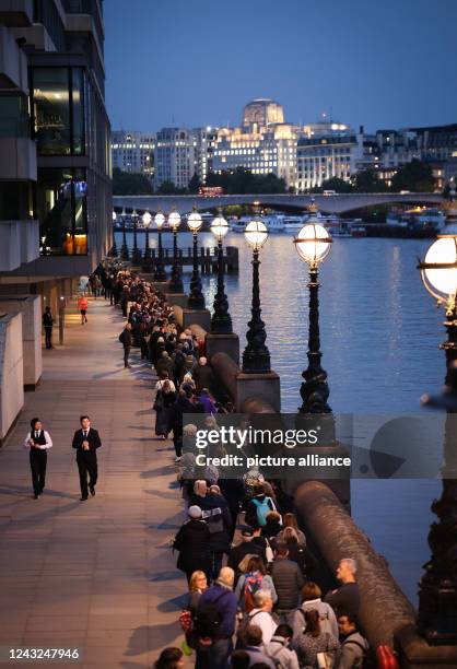 September 2022, Great Britain, London: Numerous people stand in a long queue on the Thames between Millennium Bridge and Parliament to say goodbye to...