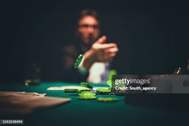 man throwing gambling chips on table - gambling table stock pictures, royalty-free photos & images