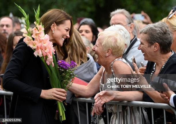 Britain's Catherine, Princess of Wales receives flowers as she chats with well-wishers outside Norwich Gate on the Sandringham Estate in Sandringham,...