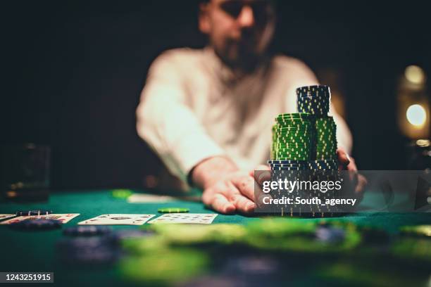 uomo che gioca a poker in una stanza buia di notte - fiche foto e immagini stock